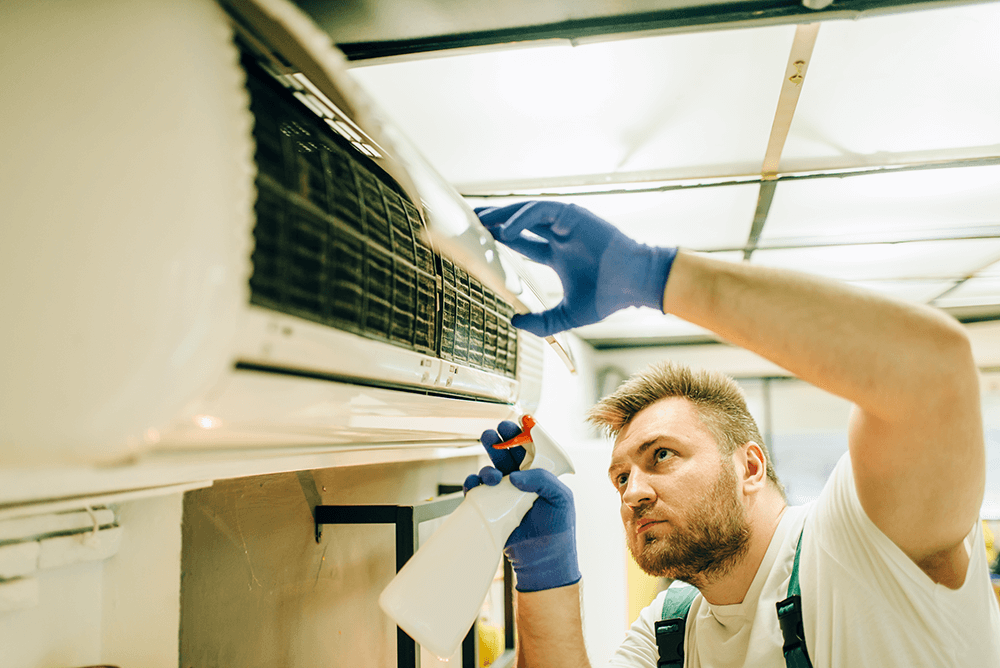 technician cleaning HVAC system