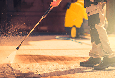 high pressure blaster removes grease from pavement