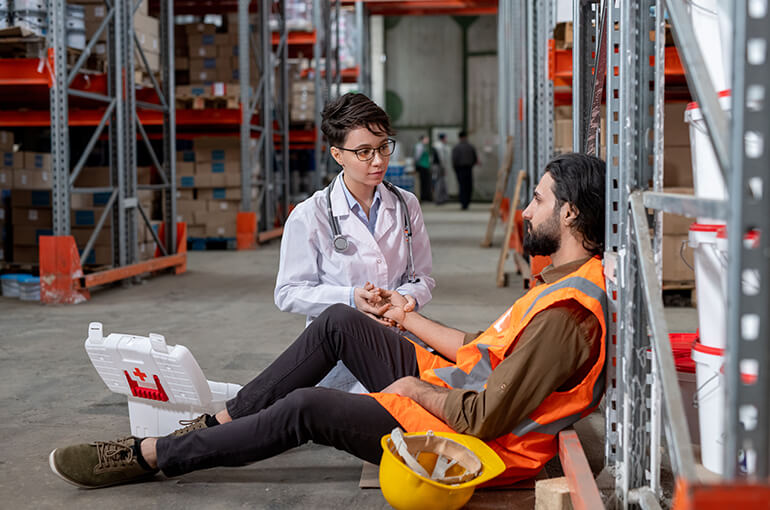 image of a warehouse worker getting medical attention after a dirty floor caused an accident